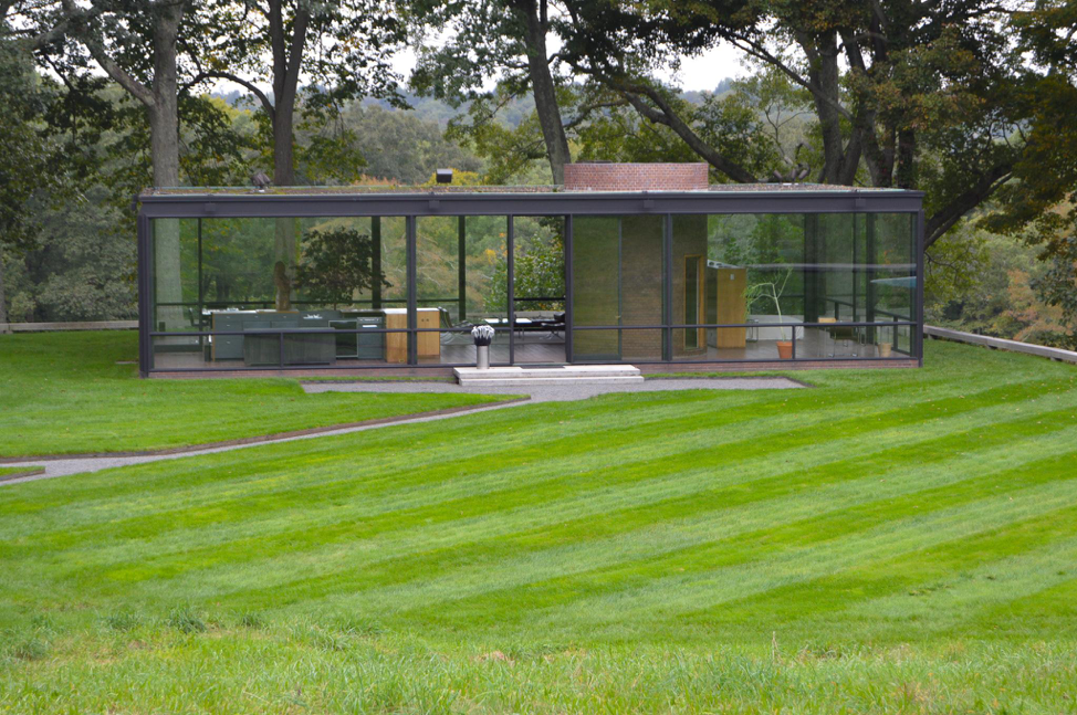 A photograph of the exterior of the Glass House, which is almost entirely see-through