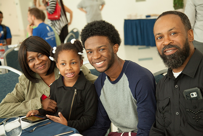 A young man and his family enjoy lunch. 