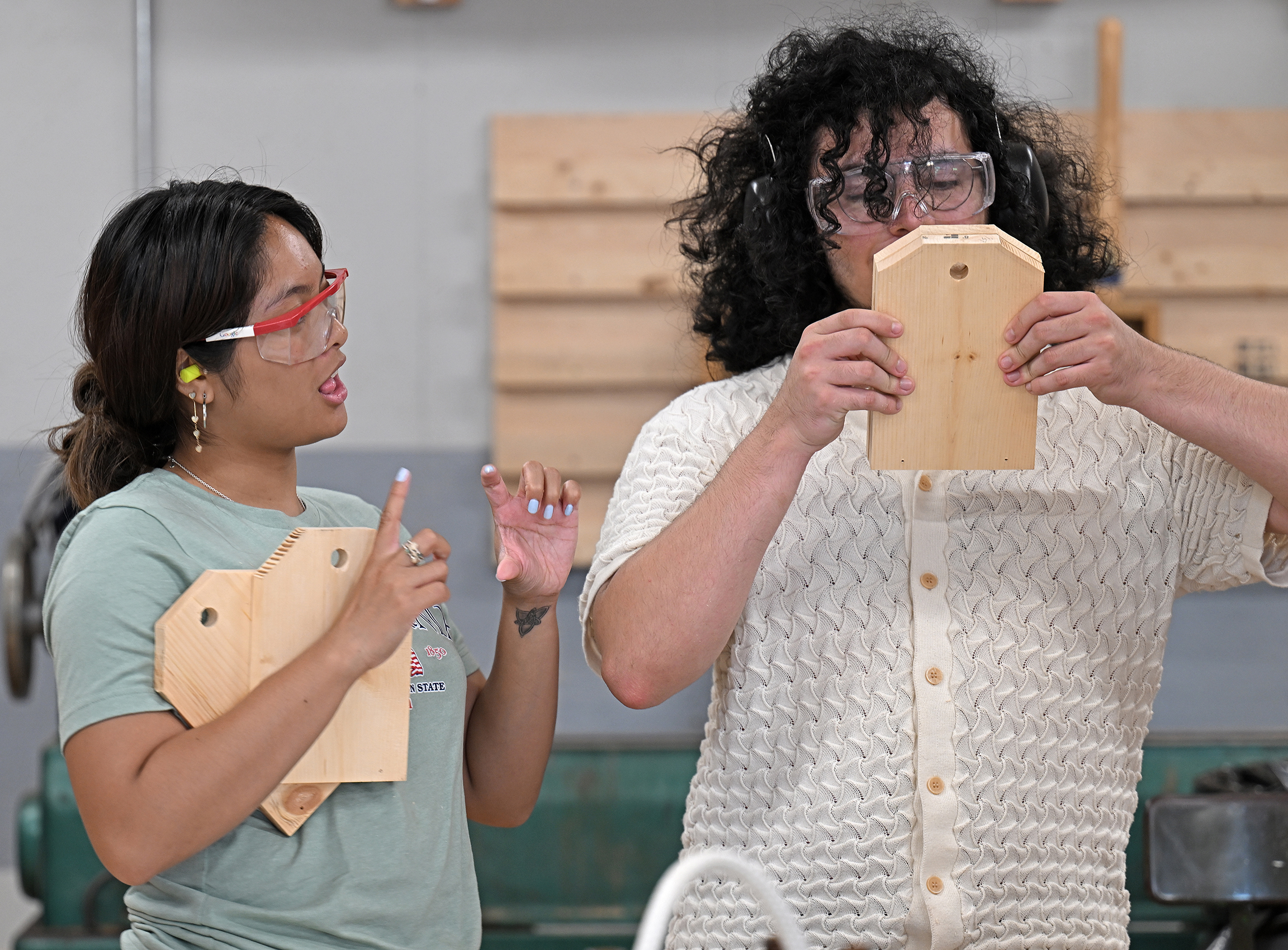 Two students talk while learning woodworking skills