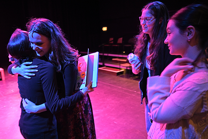 An actor is hugged by a well-wisher as two more wait to embrace her.