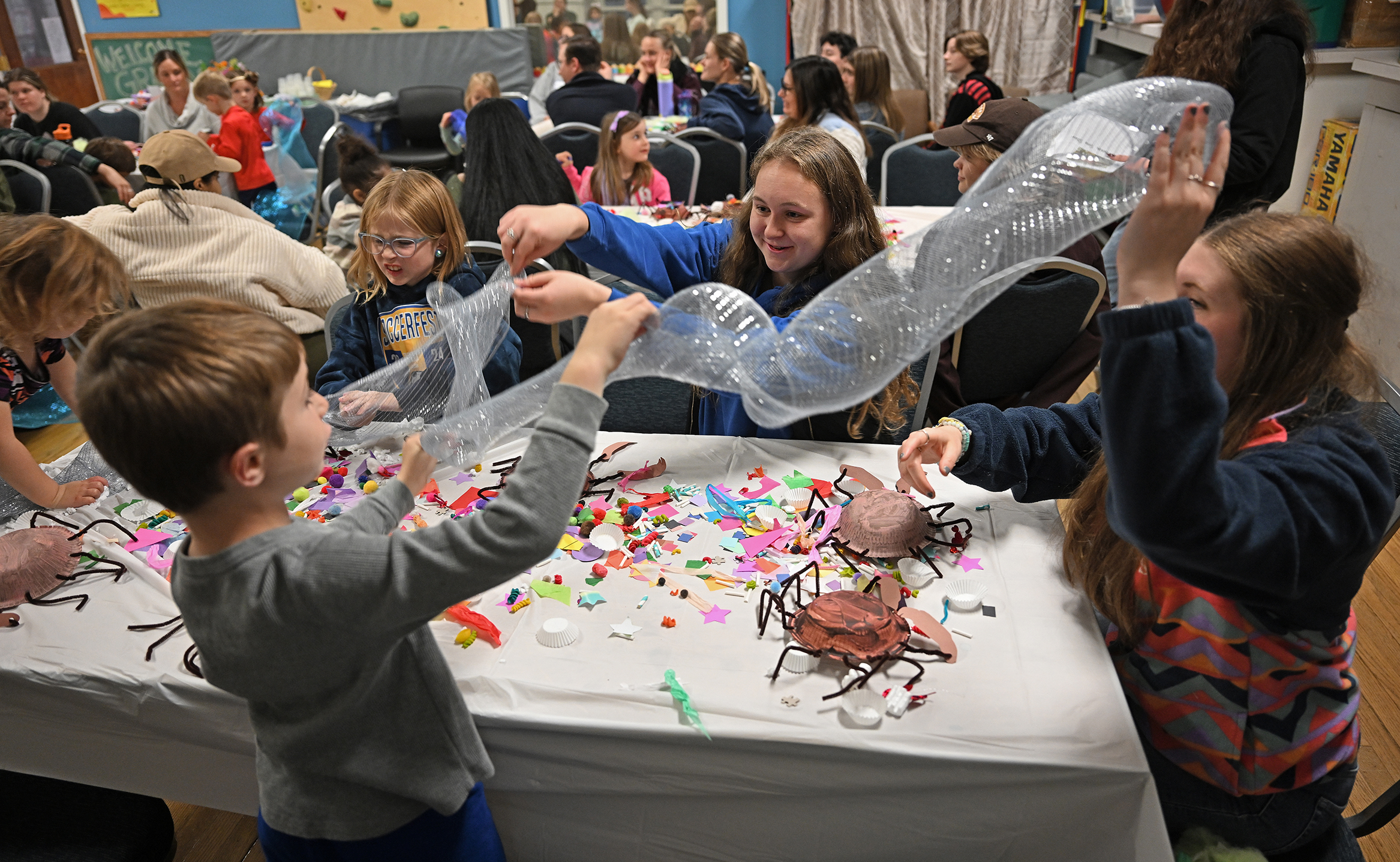 College students work on a craft project with preschool students.